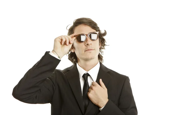 Jeune homme attrayant portant élégant costume noir et lunettes de soleil — Photo