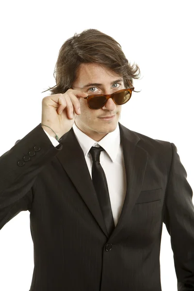 Atraktivní mladý muž v elegantní černé šaty a sluneční brýle — Stock fotografie