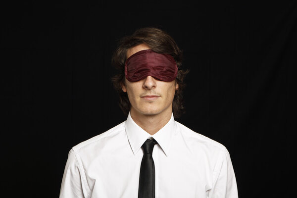 young businessman with eyes covered by sleep mask