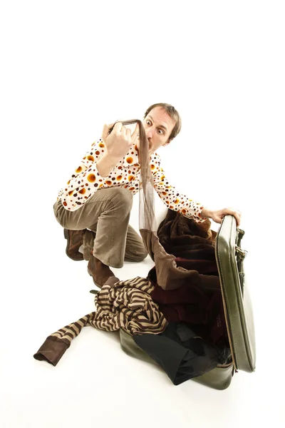 Забавный винтажный молодой человек смотрит в свой чемодан — стоковое фото