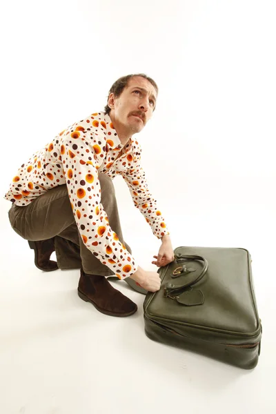 Смішний старовинний молодий чоловік дивиться у валізу — стокове фото