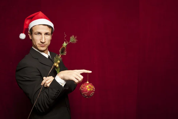 Joven divertido chico con sombrero de Navidad sobre fondo de terciopelo rojo —  Fotos de Stock