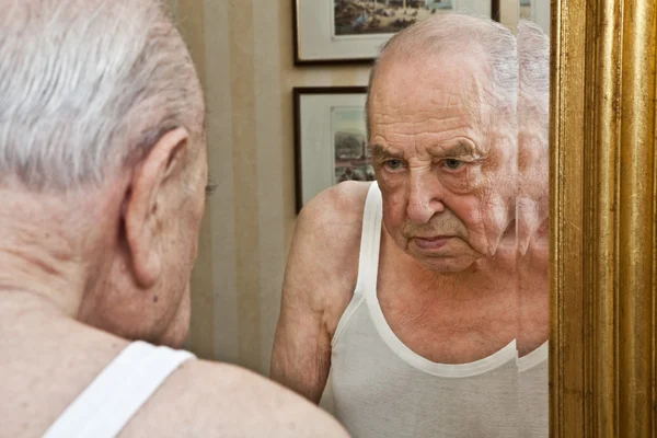 Elder pensive at the mirror — Stock Photo, Image