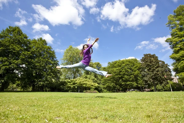 Jong meisje dansen gelukkig in een park — Stockfoto