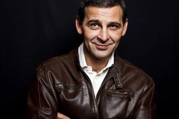 Portrait of a cool mature man with leather jacket over black bac — Stock Photo, Image