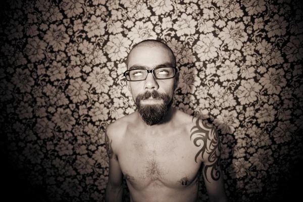 Skinny tattoo guy on floral background — Stock Photo, Image