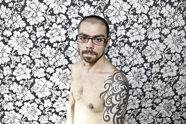 Skinny tattoo guy on floral background — Stock Photo, Image