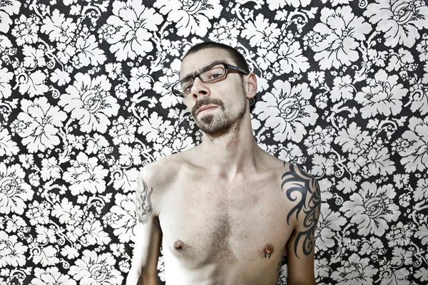Skinny tattoo guy on floral background — Stok fotoğraf