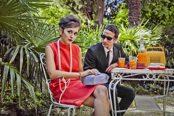 Retro estilo dos anos sessenta casal de moda tomando café da manhã ao ar livre — Fotografia de Stock