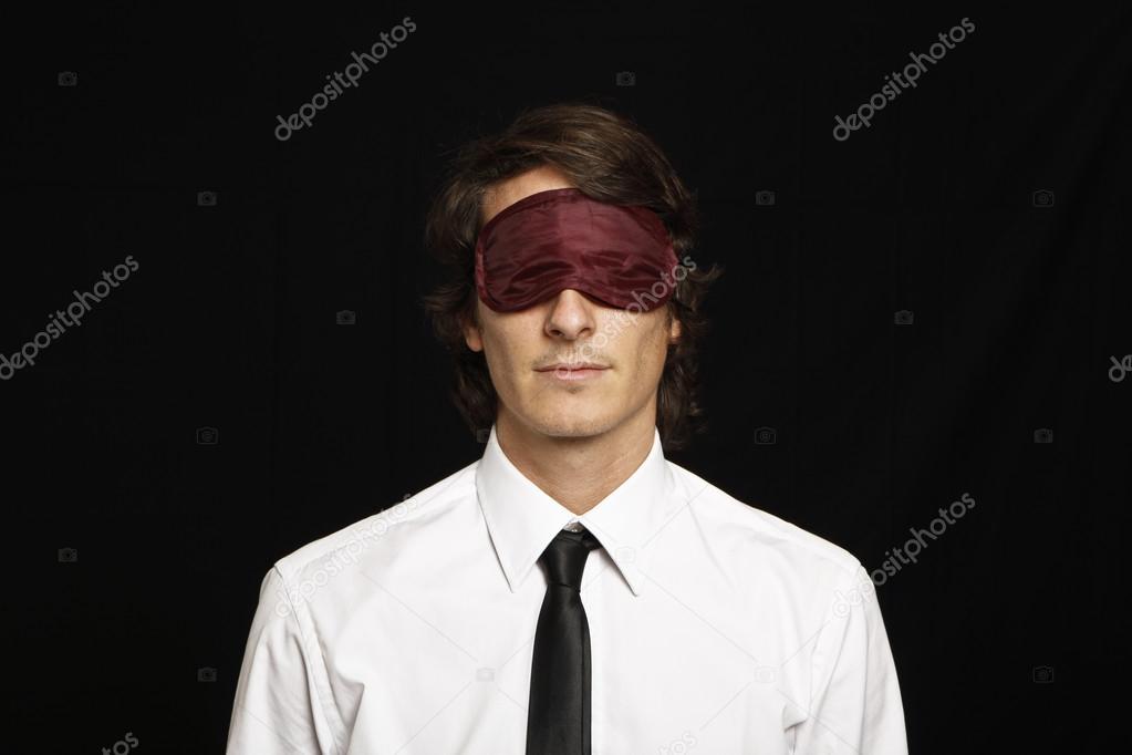 young businessman with eyes covered by sleep mask