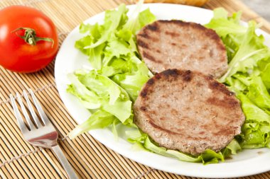 Yeşil marul üzerinde iki hamburger