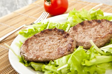 Yeşil marul üzerinde iki hamburger