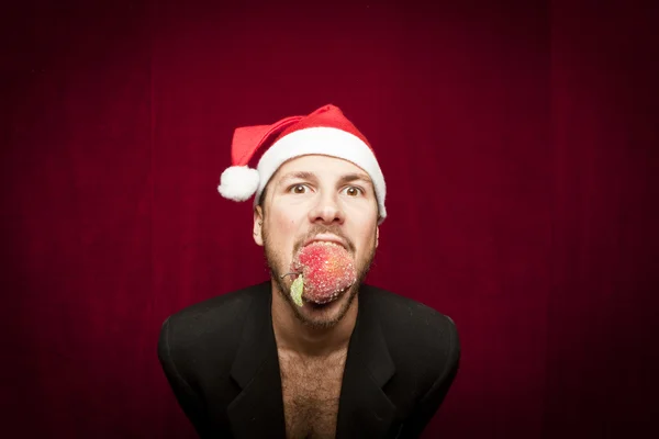 Jovem cara engraçado com chapéu de Natal no fundo valvet vermelho — Fotografia de Stock