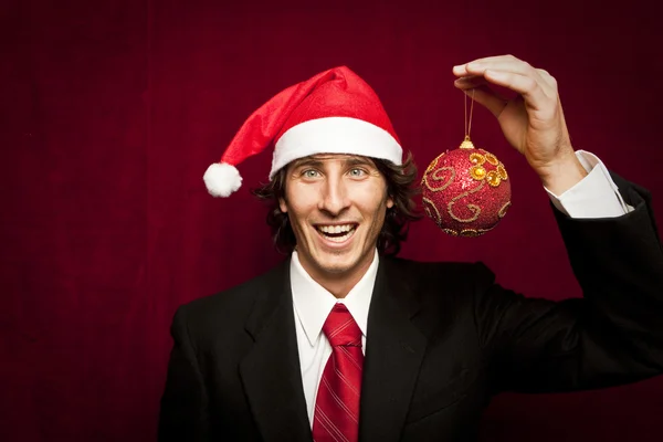 赤 valvet 背景にクリスマスの帽子と変な若い男 — ストック写真