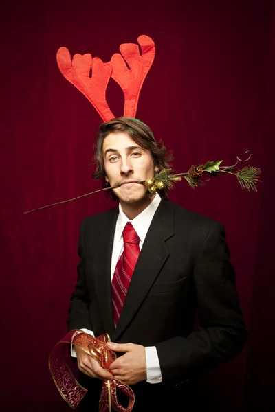 Νέοι αστείος τύπος με διακοσμήσεις Χριστουγέννων σε κόκκινο valvet backgro — Φωτογραφία Αρχείου