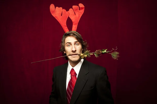 Νέοι αστείος τύπος με διακοσμήσεις Χριστουγέννων σε κόκκινο valvet backgro — Φωτογραφία Αρχείου