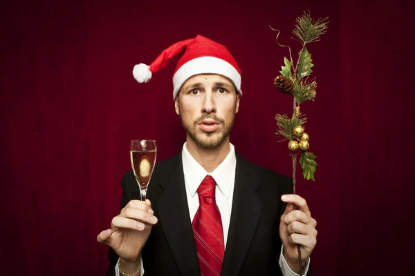 Jovem cara engraçado com chapéu de Natal no fundo valvet vermelho — Fotografia de Stock