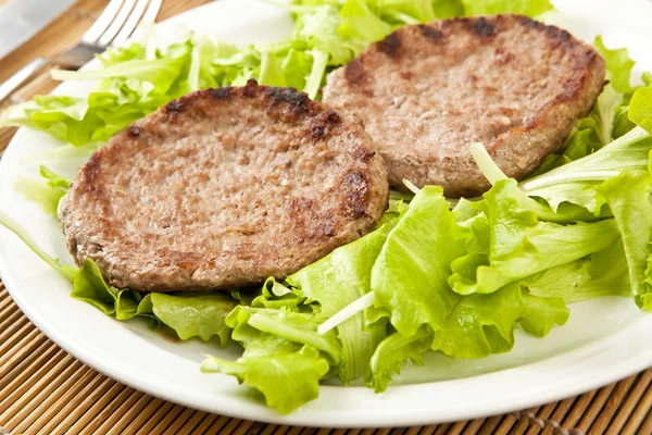 Two hamburger on green lettuce — Stock Photo, Image