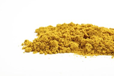 Tumeric toz, beyaz zemin üzerine sarı bir baharat.