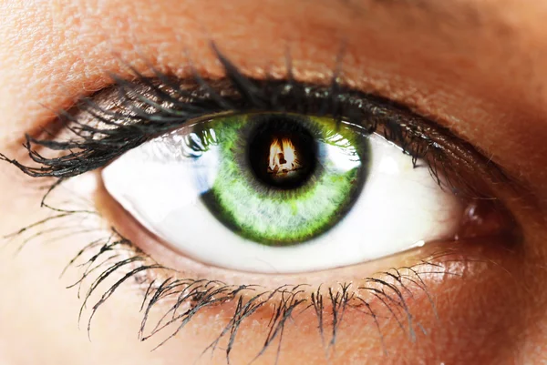 Girl's green eye close up with fire reflected green eye close u — Stock Photo, Image