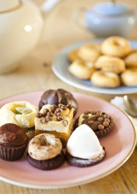 pasta ve bisküvi ve ahşap masa çay potu plakaları