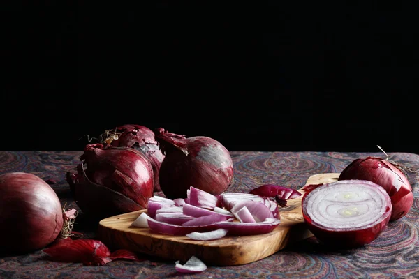 Elegantní červené cibule na prkně — Stock fotografie