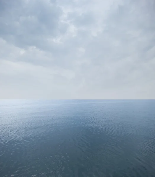 Mar tranquilo con cielo nublado en el horizonte — Foto de Stock