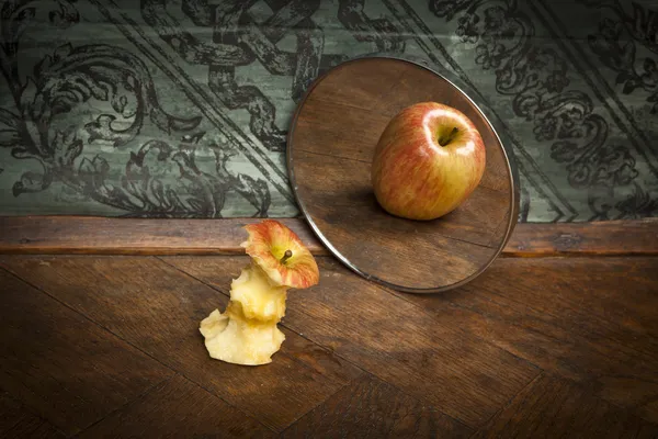 Surrealistic picture of an apple reflecting in the mirror — Stock Photo, Image