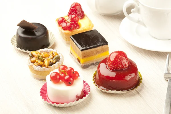 Different sort of beautiful pastry, small colorful sweet cakes — Stock Photo, Image