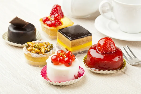 Different sort of beautiful pastry, small colorful sweet cakes — Stock Photo, Image