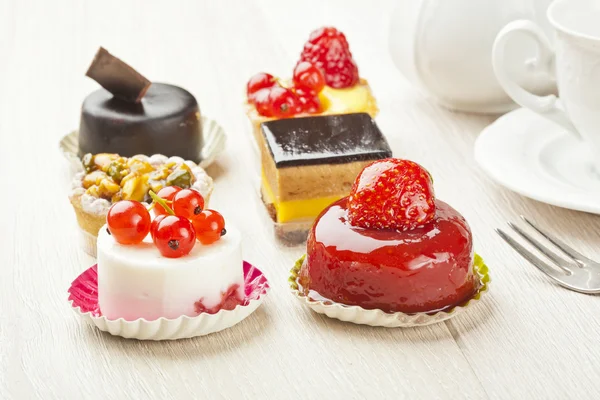 Diferente tipo de pastelería hermosa, pequeños pasteles dulces de colores — Foto de Stock