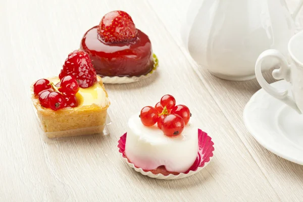 Fruit pastry little cake with tea cup on white wooden table — Stock Photo, Image