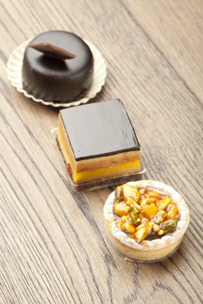 Pastelaria de chocolate pequeno bolo na mesa de madeira — Fotografia de Stock