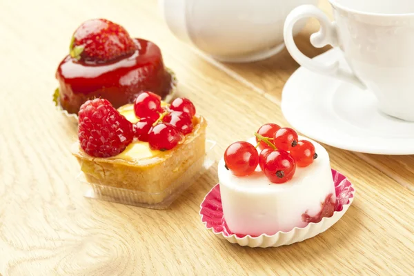 Fruit pastry little cake with tea cup on wooden table — Stock Photo, Image