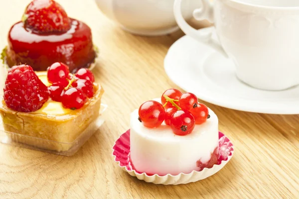 Gyümölcs sütemény tea cup-a fából készült asztal kis torta — Stock Fotó