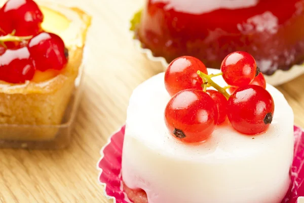 Kleine mooie rode vruchten gebak op houten tafel — Stockfoto