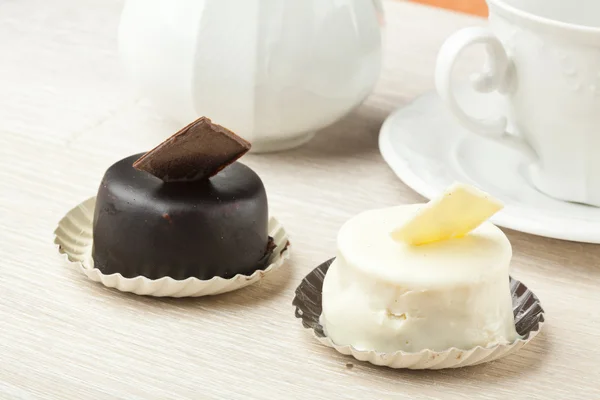 Chocolate pastry little cake with tea cup on wooden table — Stock Photo, Image