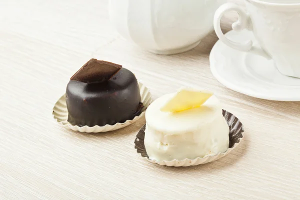 Kue coklat kecil dengan cangkir teh di atas meja kayu — Stok Foto
