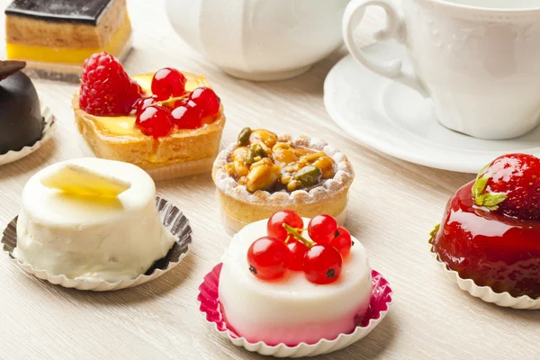 Different sort of beautiful pastry, small colorful sweet cakes — Stock Photo, Image