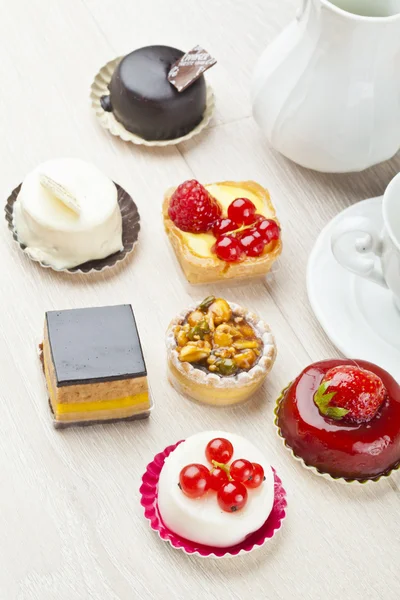 Different sort of beautiful pastry, small colorful sweet cakes — Stock Photo, Image