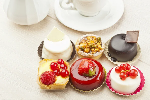 Különböző típusú gyönyörű sütemények, kis színes édes sütemények — Stock Fotó