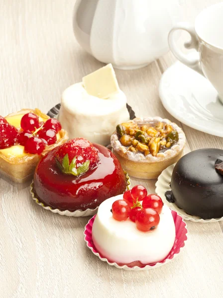 Different sort of beautiful pastry, small colorful sweet cakes — Stock Photo, Image