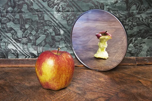 Imagem surrealista de uma maçã refletindo no espelho Fotografia De Stock