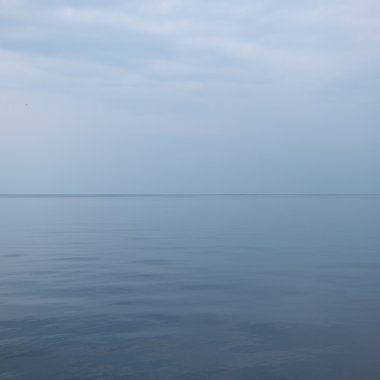 gri gökyüzü ile sakin deniz