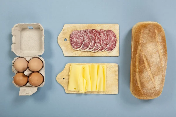 Salami sandwich ingrediënten op blauwe achtergrond — Stockfoto