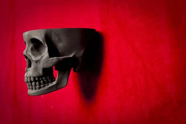 Black scary human skull on red velvet background — Stock Photo, Image