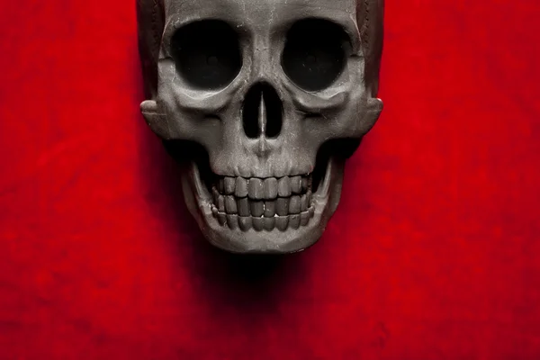 Black scary human skull on red velvet background — Stock Photo, Image