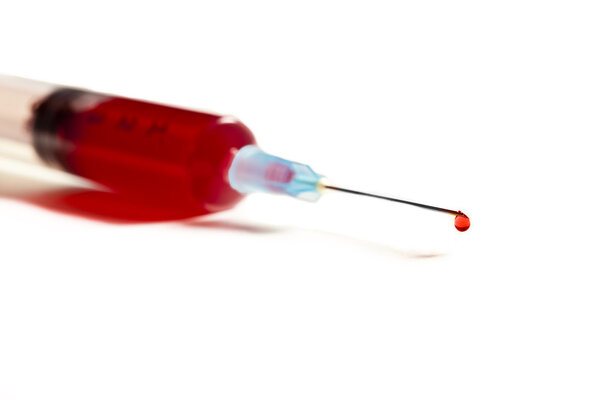 Шприц с кровью, выделенной на белом
