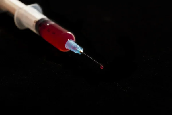 Syringe with blood isolated on black — Stock Photo, Image