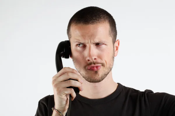 Молодой человек с эмоциями у телефона — стоковое фото